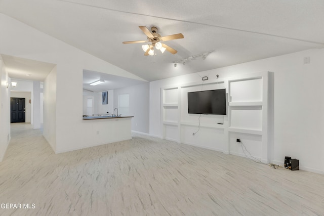 unfurnished living room with ceiling fan, sink, light hardwood / wood-style floors, and vaulted ceiling