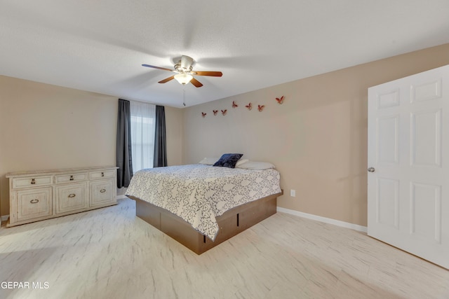 bedroom with ceiling fan, a textured ceiling, and light wood-type flooring