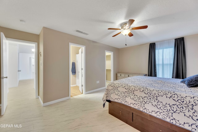 bedroom featuring ceiling fan, a textured ceiling, and ensuite bath