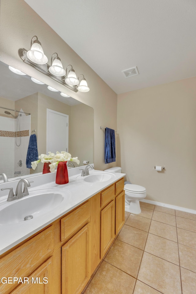 bathroom featuring tile patterned flooring, vanity, toilet, and a shower