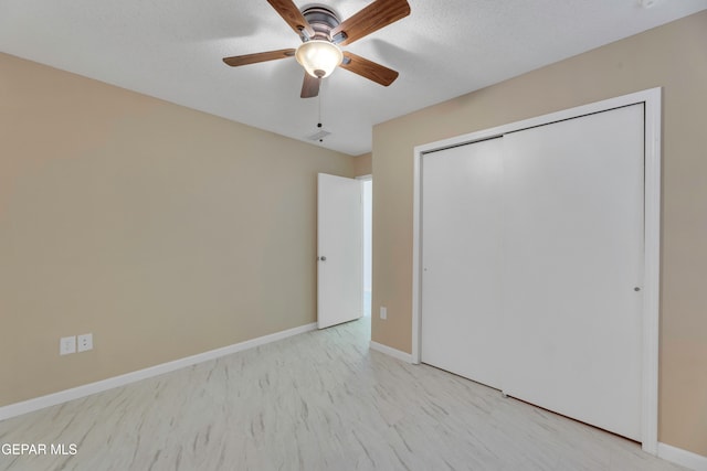 unfurnished bedroom with ceiling fan, a textured ceiling, and a closet