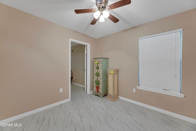 unfurnished room with a textured ceiling and ceiling fan