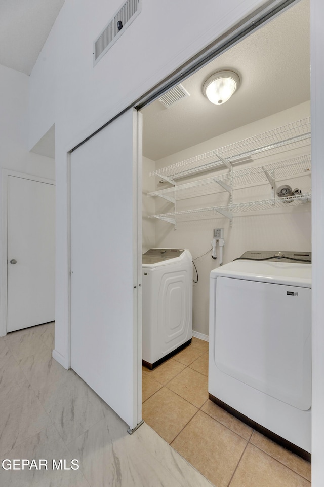 clothes washing area with washing machine and clothes dryer