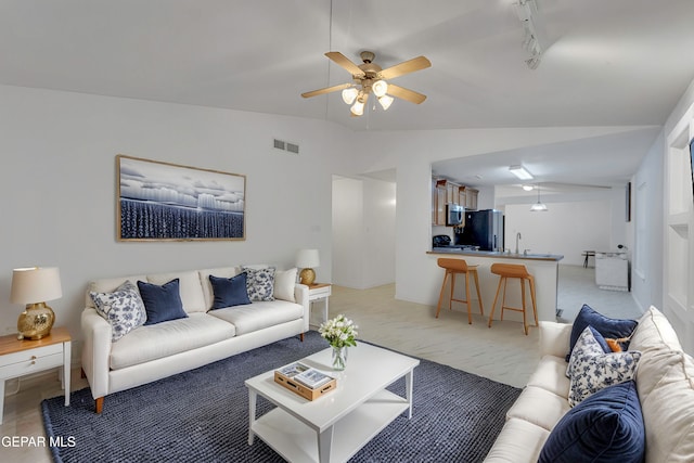 carpeted living room featuring rail lighting, vaulted ceiling, and ceiling fan