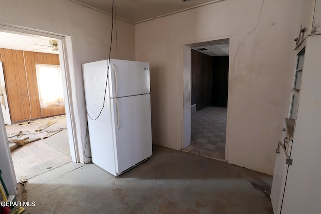 kitchen with white refrigerator and wooden walls