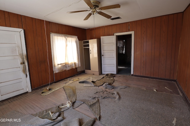 interior space featuring hardwood / wood-style floors, ensuite bathroom, and wooden walls