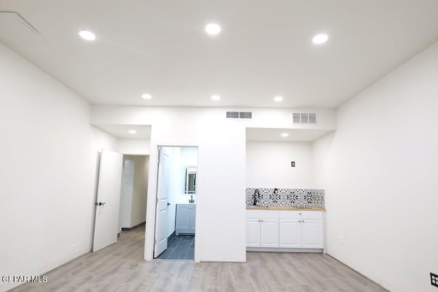 kitchen featuring backsplash, light hardwood / wood-style flooring, and sink