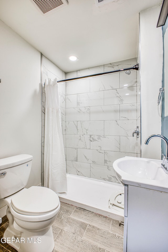 bathroom with a shower with curtain, vanity, and toilet