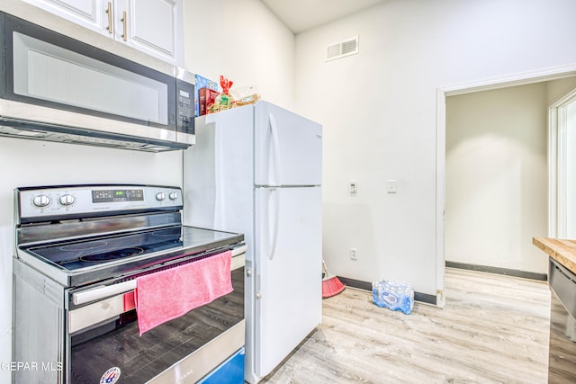 kitchen featuring white cabinets, stainless steel appliances, and light hardwood / wood-style flooring