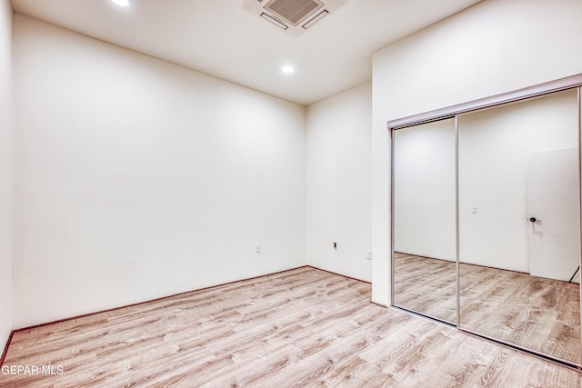 unfurnished bedroom featuring light wood-type flooring and a closet