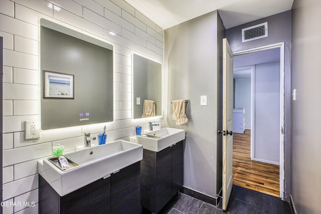 bathroom with vanity, hardwood / wood-style flooring, and tile walls