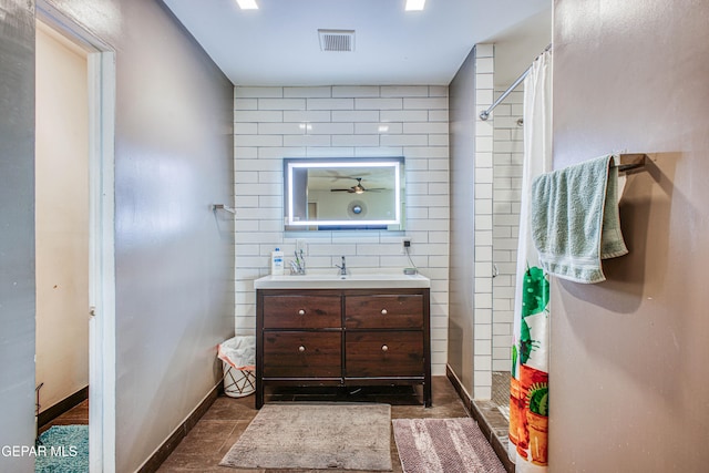 bathroom featuring tile patterned flooring, vanity, curtained shower, and tile walls