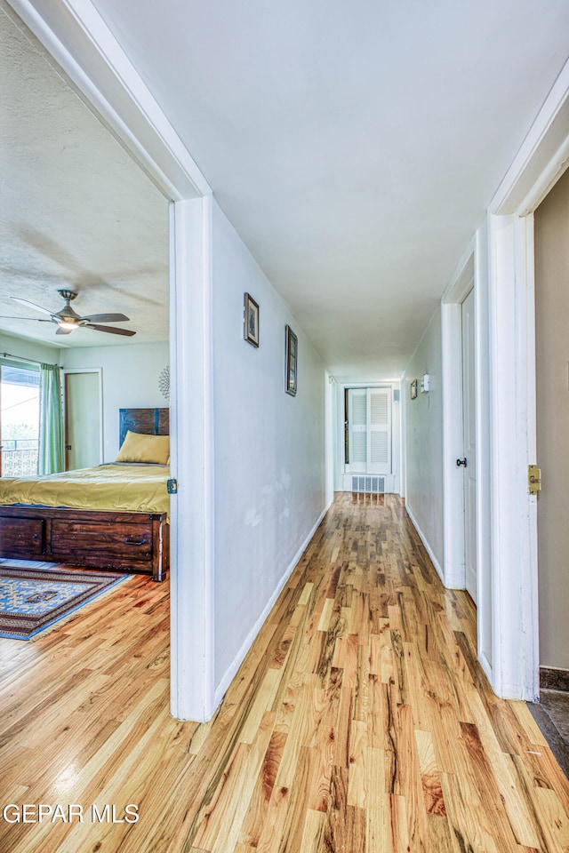 hallway with light hardwood / wood-style floors