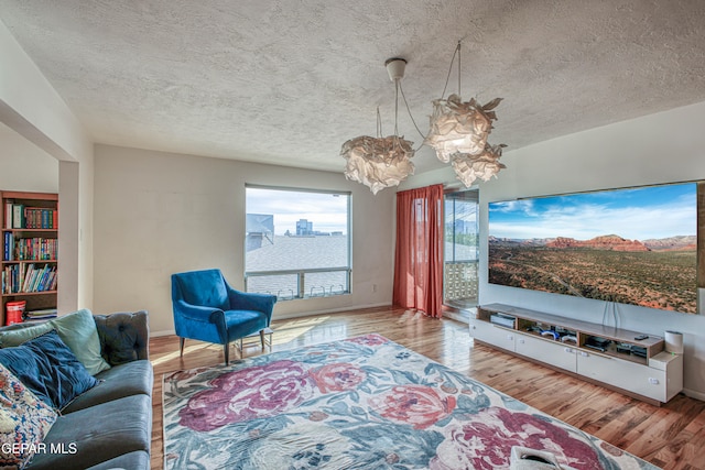 living room with a textured ceiling and light hardwood / wood-style flooring