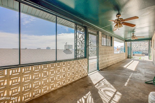 unfurnished sunroom featuring ceiling fan