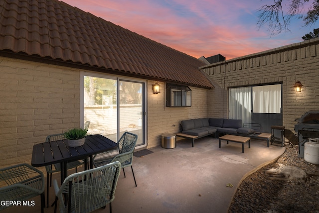 patio terrace at dusk with grilling area and an outdoor hangout area