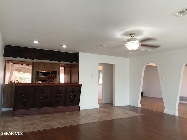 unfurnished living room with wood-type flooring, plenty of natural light, and ceiling fan