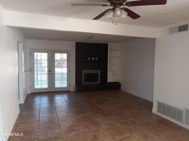 unfurnished living room with tile patterned floors, ceiling fan, french doors, and a textured ceiling