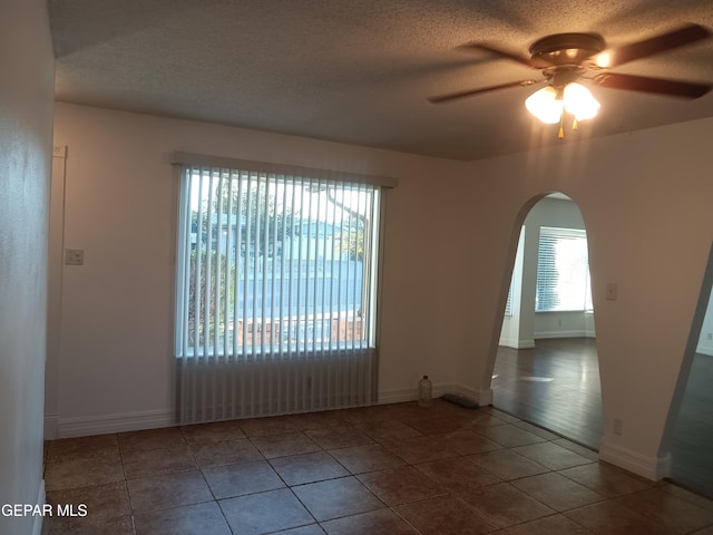 tiled spare room with ceiling fan and a textured ceiling