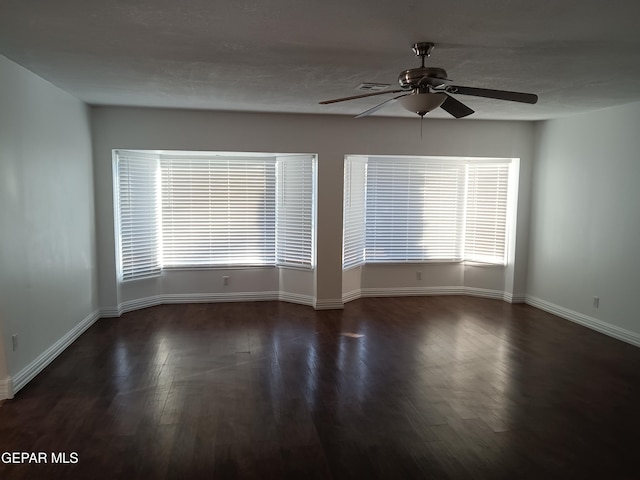 spare room with ceiling fan and dark hardwood / wood-style flooring