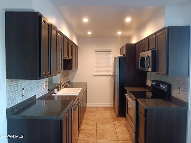 kitchen featuring decorative backsplash, light tile patterned floors, sink, and appliances with stainless steel finishes