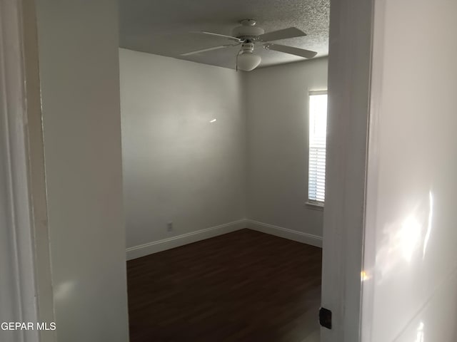 spare room featuring ceiling fan and dark wood-type flooring