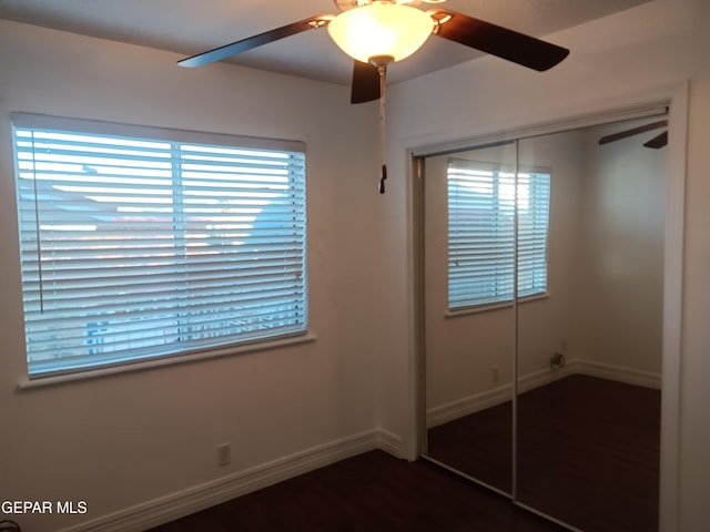 unfurnished bedroom featuring ceiling fan, dark hardwood / wood-style floors, and a closet