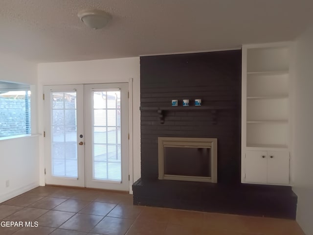 doorway with built in shelves, french doors, a textured ceiling, and tile patterned flooring