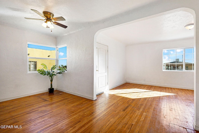 empty room with hardwood / wood-style floors and ceiling fan