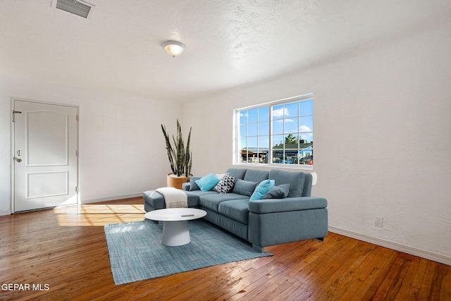 living room with wood-type flooring and a textured ceiling