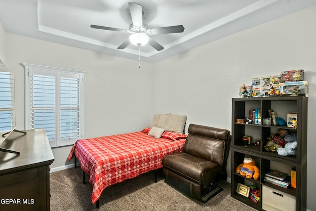 bedroom featuring a tray ceiling, ceiling fan, and carpet