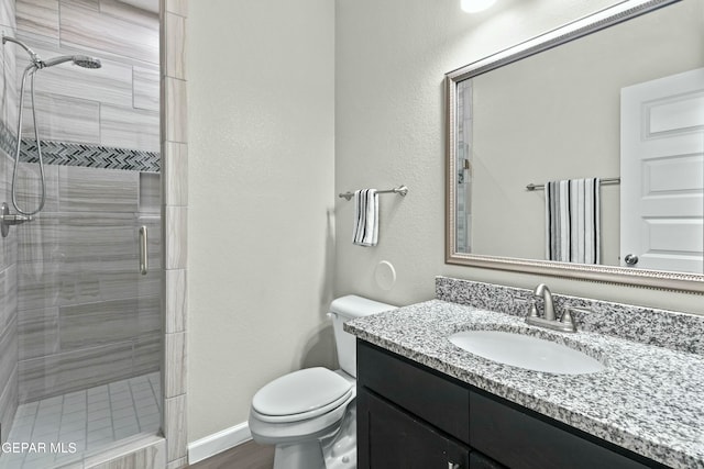 bathroom with hardwood / wood-style flooring, vanity, an enclosed shower, and toilet