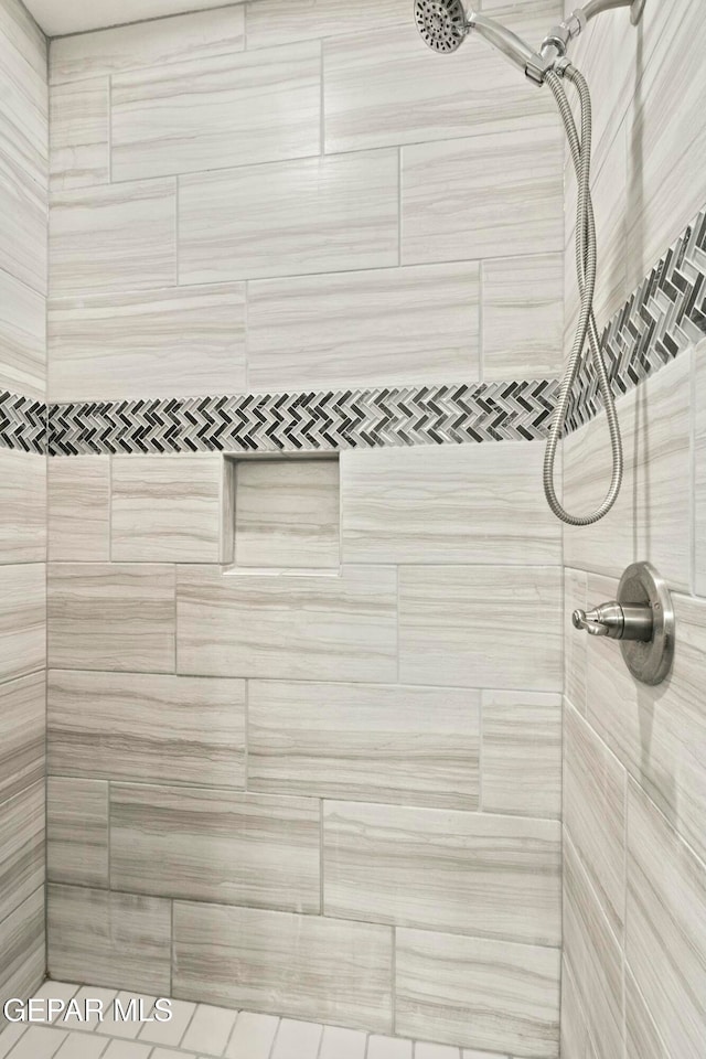 interior details featuring a tile shower