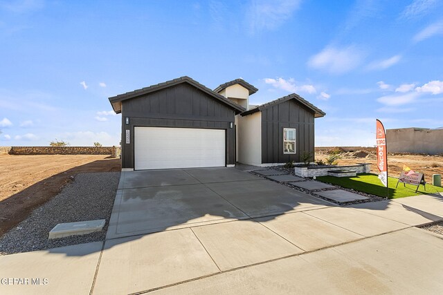 15224 Gauge Ct, El Paso, TX 79938 - view of front of house with concrete driveway, an attached garage, board and batten siding, and a tile roof