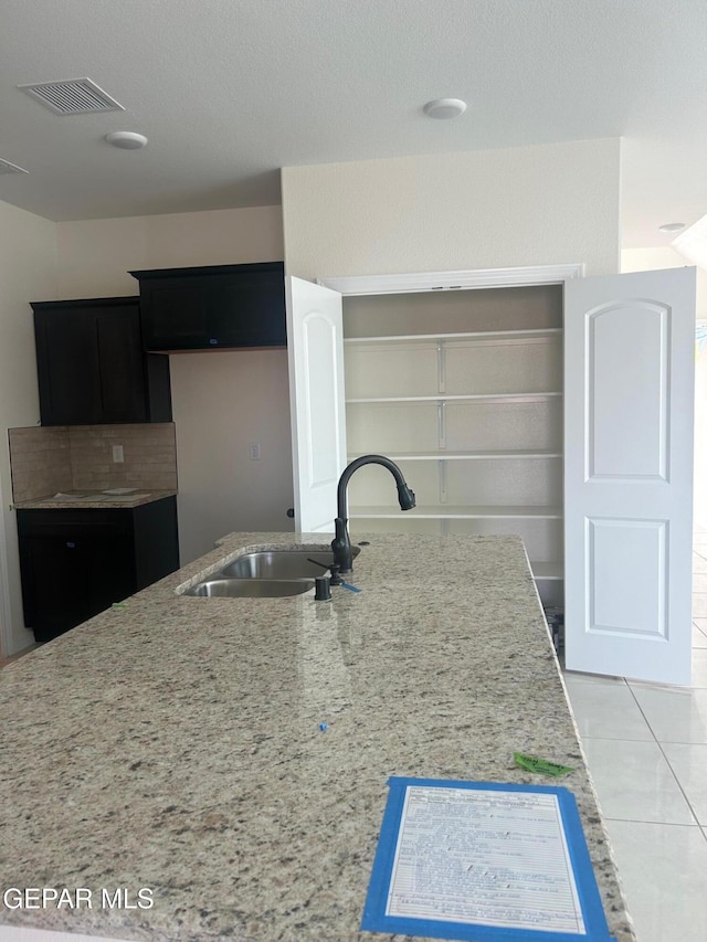 kitchen featuring sink, backsplash, and tile patterned floors