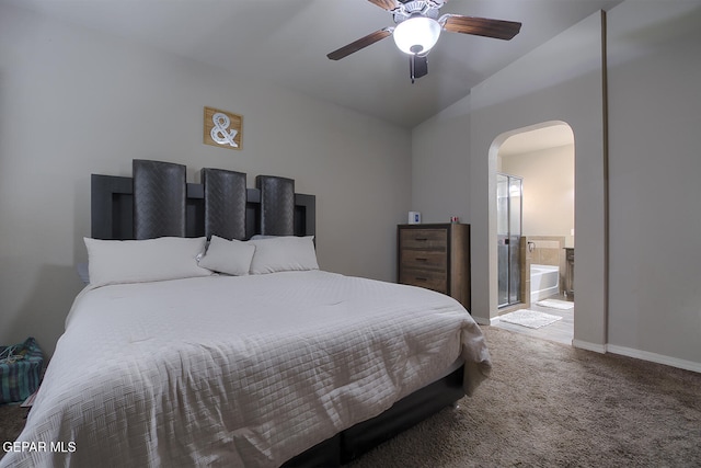 carpeted bedroom with ensuite bath, vaulted ceiling, and ceiling fan