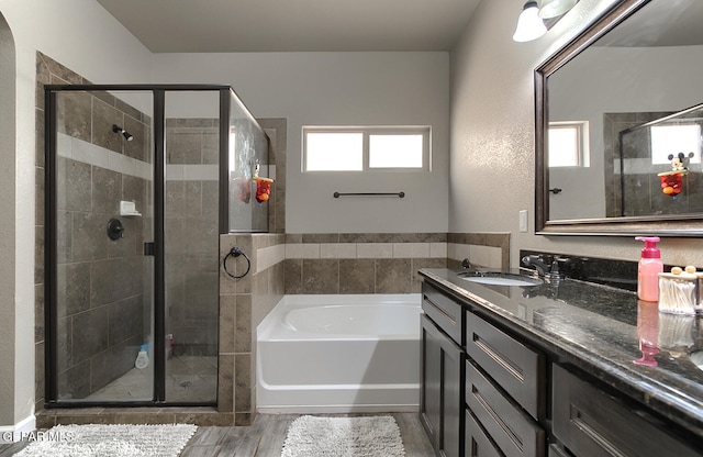 bathroom with separate shower and tub, hardwood / wood-style floors, and vanity