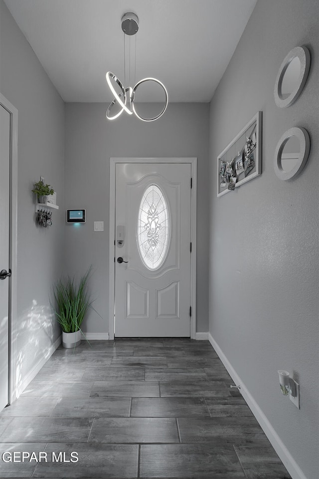 foyer with a chandelier and dark hardwood / wood-style flooring