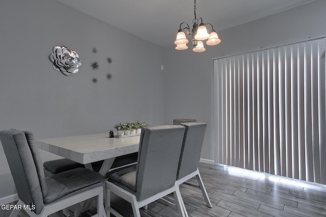 dining area with light hardwood / wood-style floors and an inviting chandelier