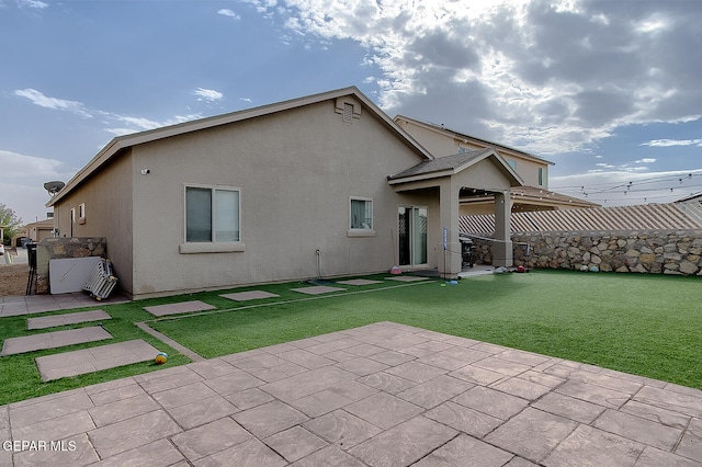 rear view of house with a yard and a patio area