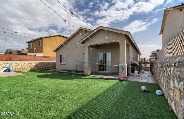 back of property featuring a patio area and a lawn