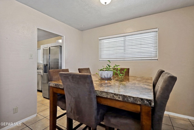 dining room featuring a textured ceiling and light tile patterned flooring