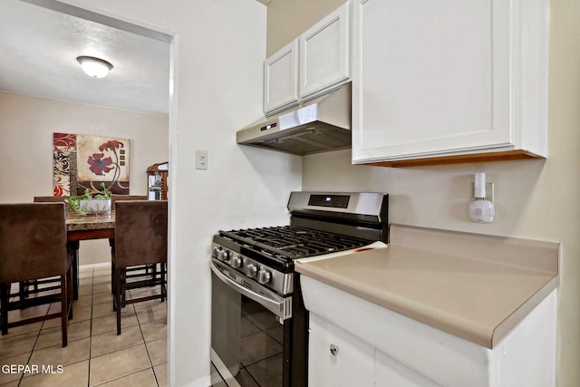 kitchen with gas range, light tile patterned floors, and white cabinetry