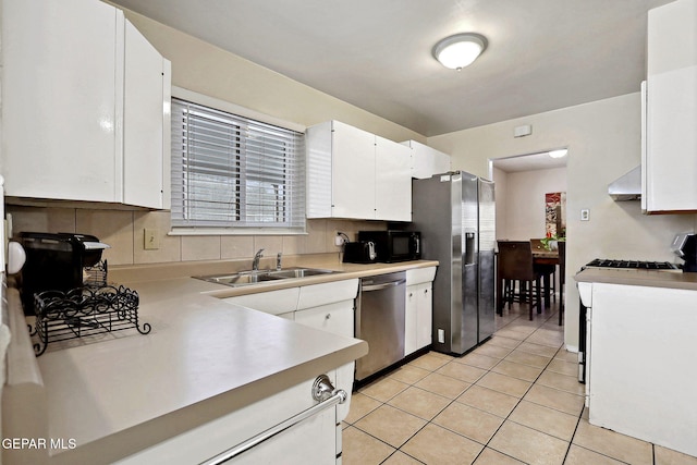 kitchen featuring sink, white cabinetry, stainless steel appliances, and light tile patterned floors