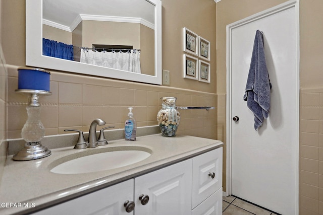 bathroom featuring tile patterned floors, vanity, ornamental molding, and tile walls