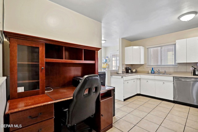 kitchen with stainless steel dishwasher, white cabinets, light tile patterned floors, and sink