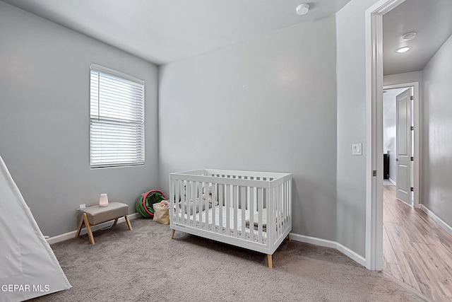 carpeted bedroom with a nursery area