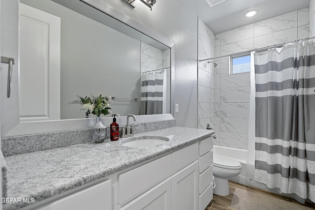 full bathroom with hardwood / wood-style floors, vanity, toilet, and shower / bath combo with shower curtain