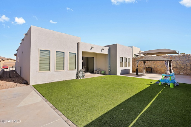 back of property featuring a gazebo, a lawn, and a patio