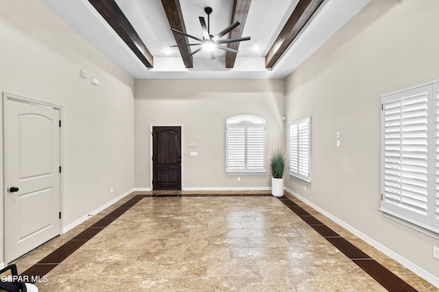 entryway featuring beamed ceiling, ceiling fan, and a high ceiling